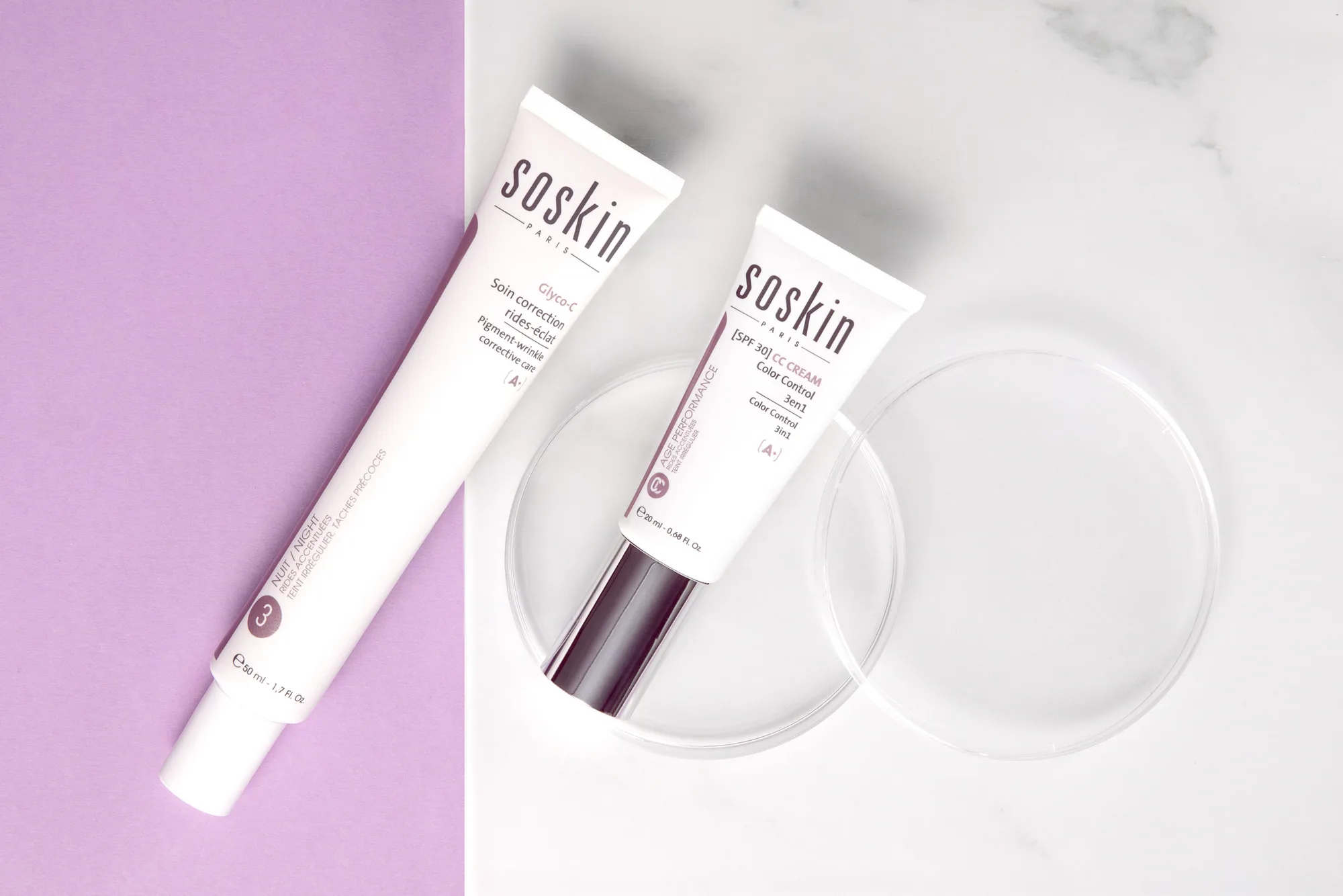 Deux soins visage SOSkin Paris posés sur un fond bicolore lilas et marbre blanc, éclairage de studio